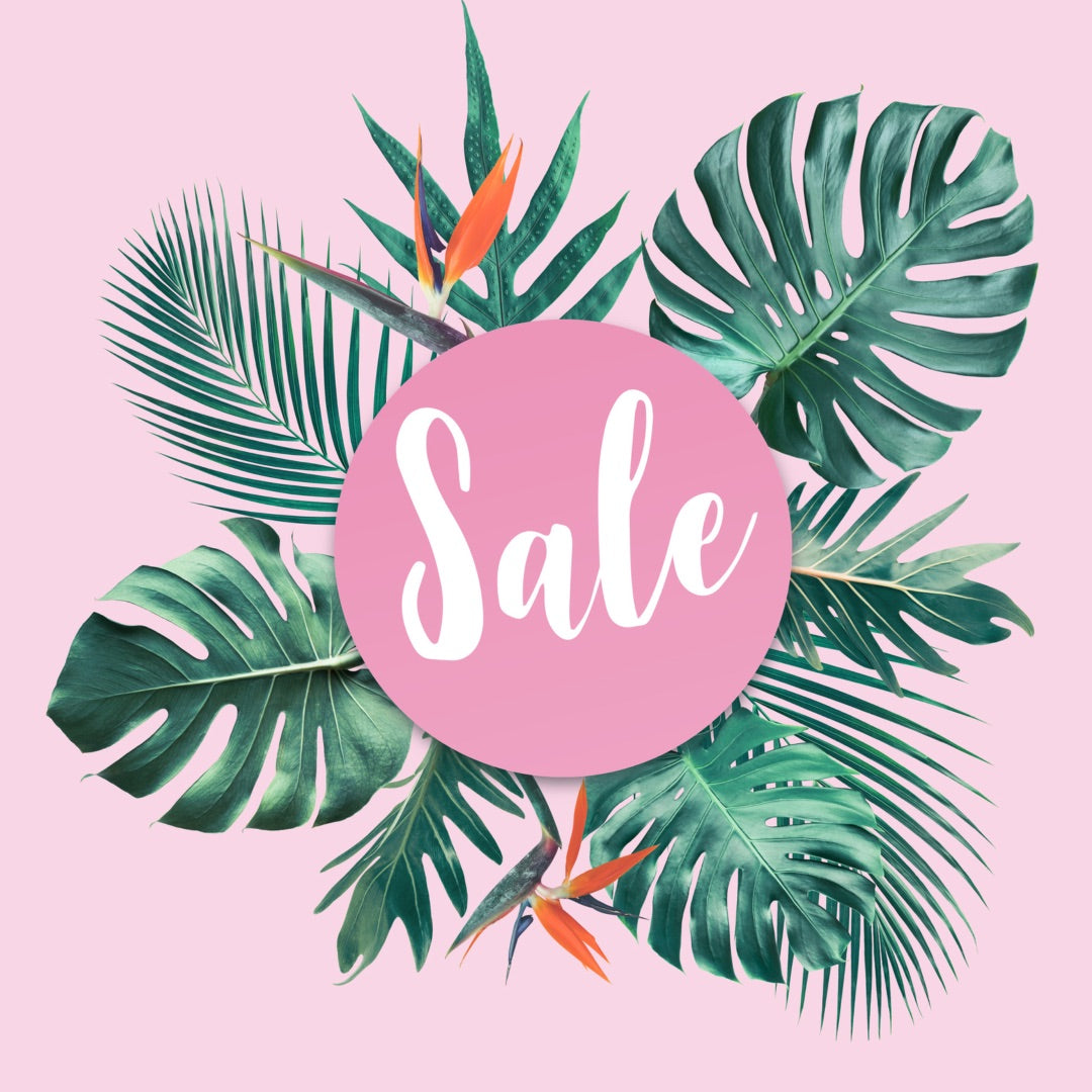 Sale sign with green palm leaves in background 