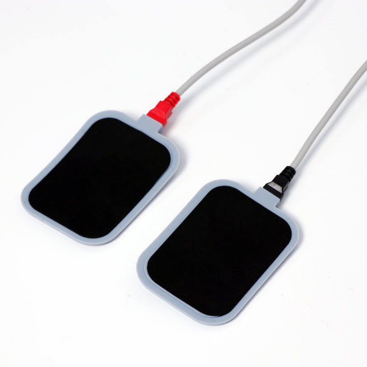 Pair of rectangular body treatment electrode pads with red and black connector cables for professional aesthetic machine treatments.